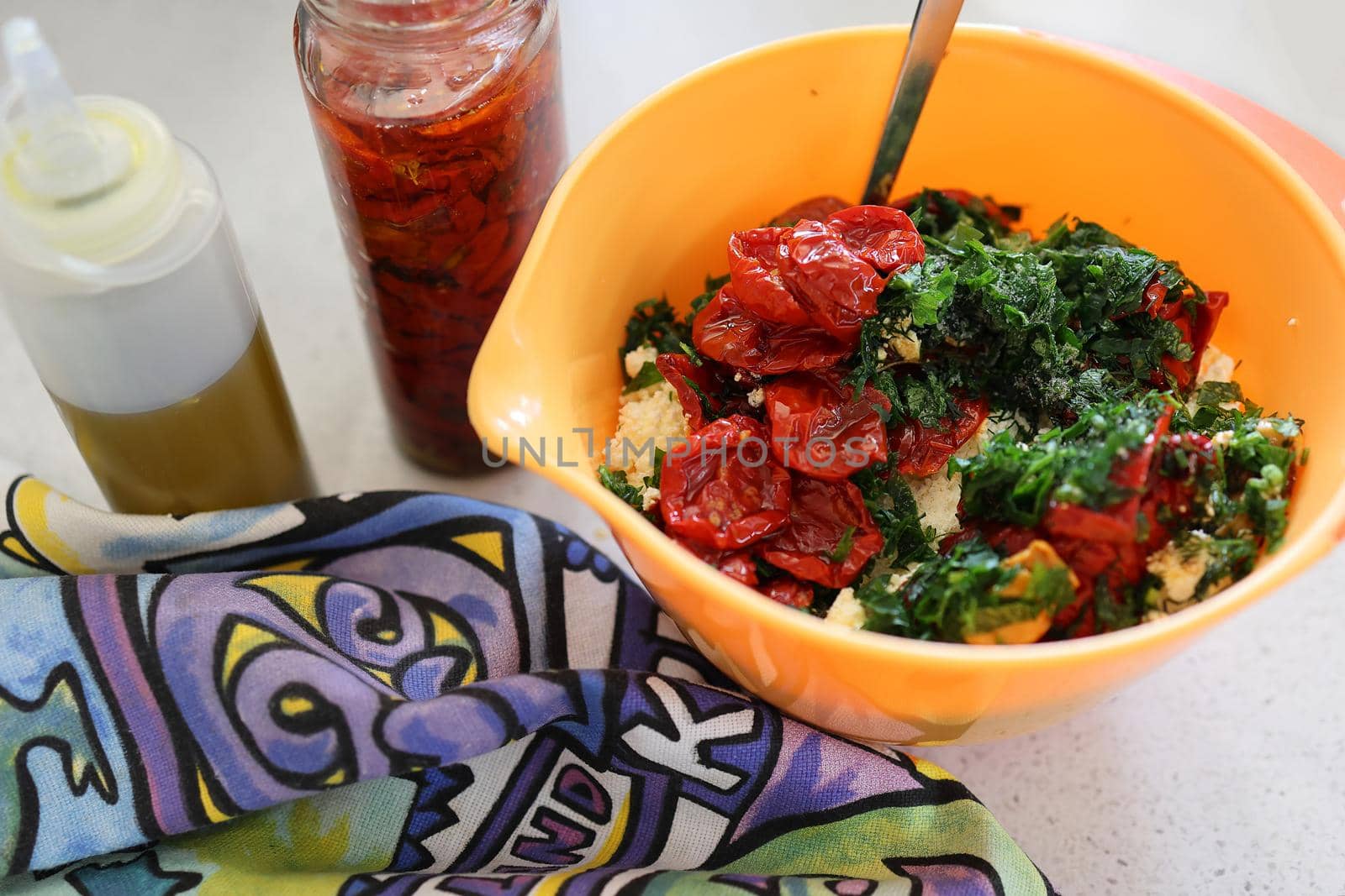 Making dip from homemade cottage cheese. sun-dried tomatoes and herbs with olive oil. Ingredients in an orange bowl, a bottle of olive oil and a jar of sun dried tomatoes. Tasty and healthy food. by Proxima13