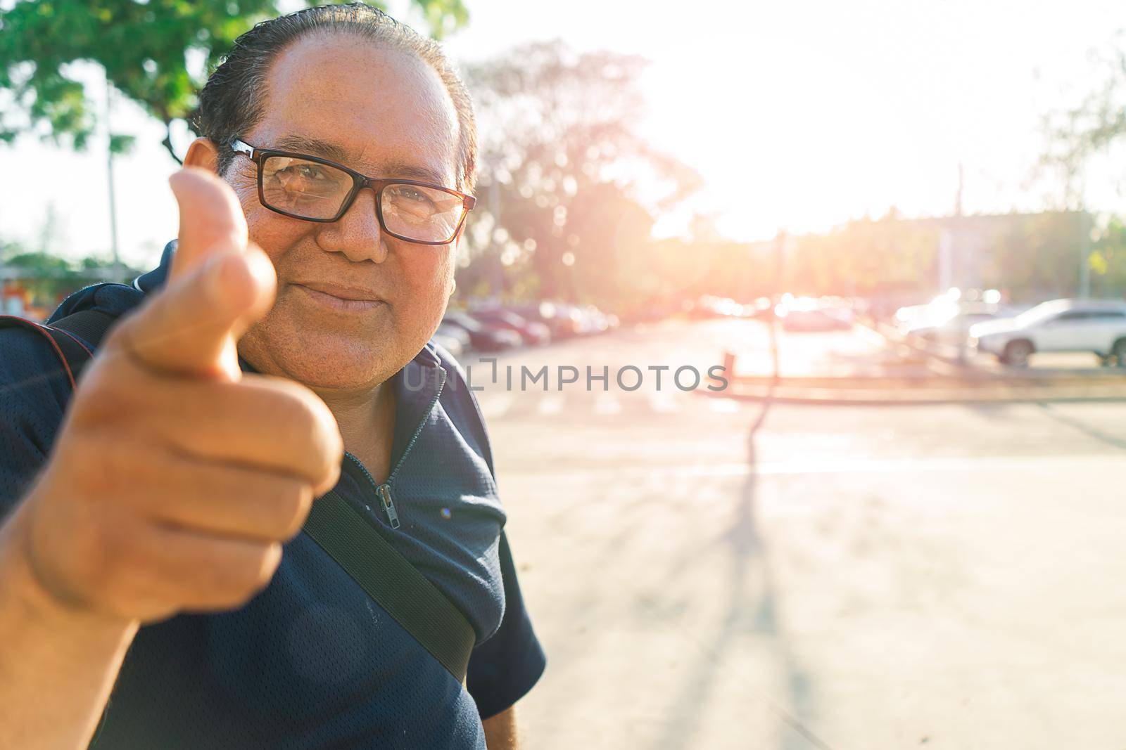 Photo with copy space of a local mature Latin tourist man pointing his finger at the camera during sunset in an outdoor park by cfalvarez