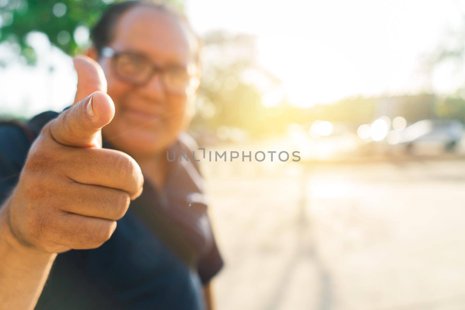 Photo with copy space and selective focus of a local tourist mature Latin man pointing his finger at the camera during sunset in an outdoor park by cfalvarez