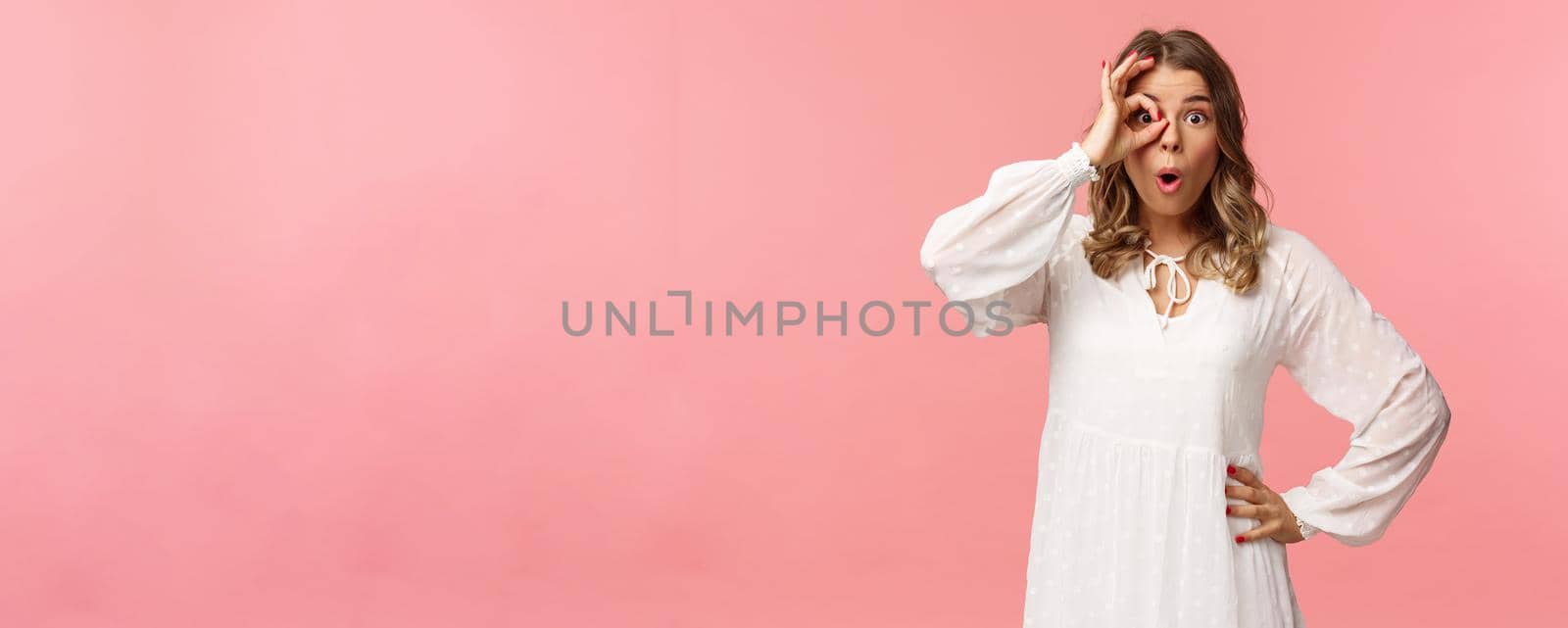 Portrait of amazed and intrigued young blond girl seeing something awesome, look from okay sign with startled excited expression, fold lips say wow, pop eyes at camera, pink background by Benzoix