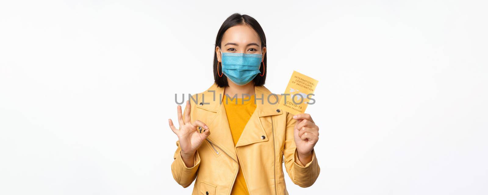 Hey you got point. Cheerful cute asian lively girl dark short haircut pointing camera finger-pistol smiling broadly, encourage friend make move, congratulate coworker good job, stand blue background.