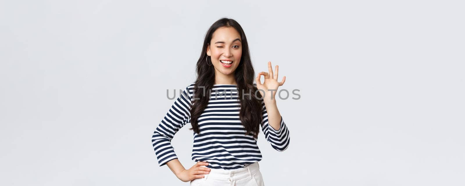 Lifestyle, beauty and fashion, people emotions concept. Satisfied good-looking female guarantee quality of product, recommend advertisement, showing okay sign, say no problem, all good.