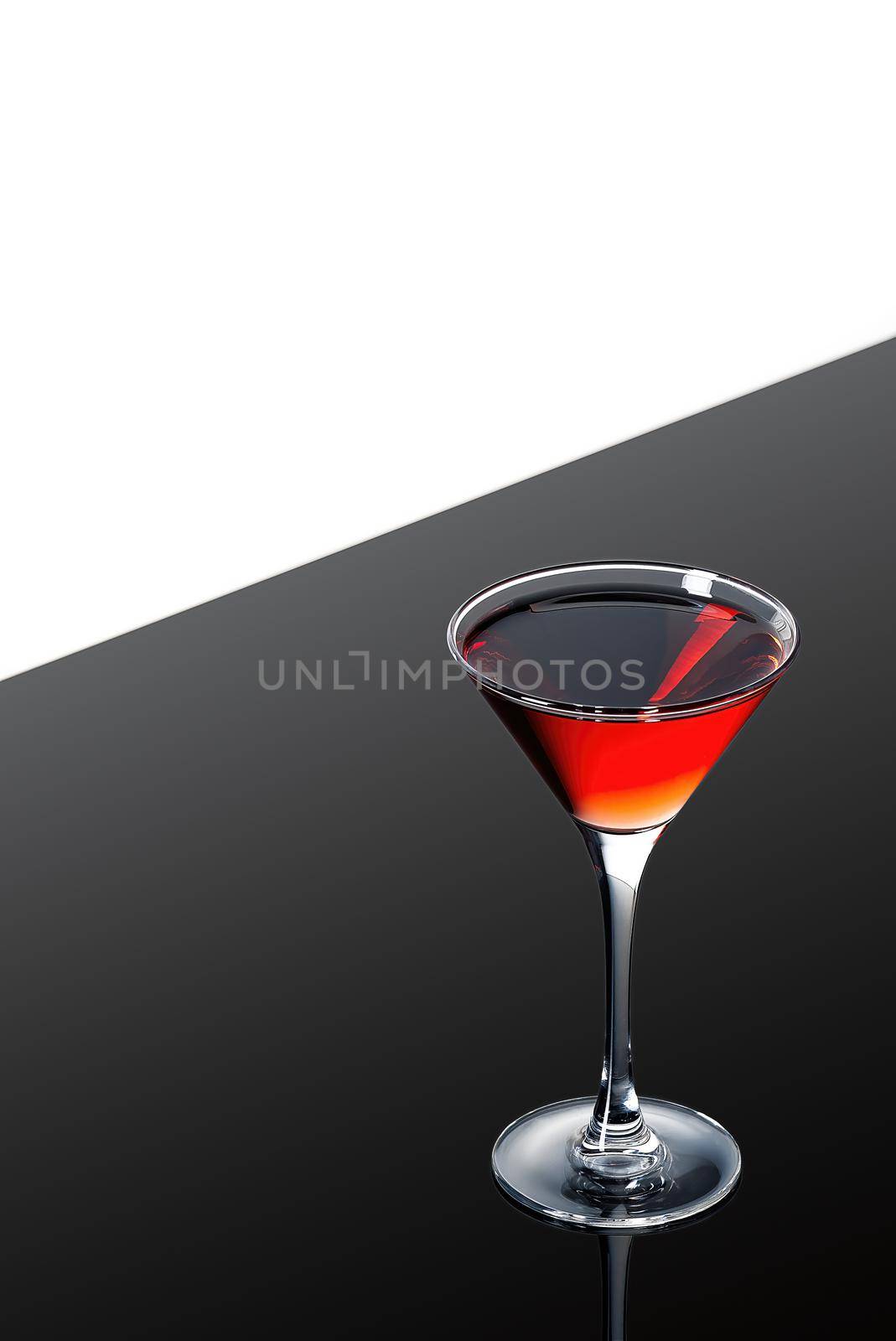 red martini cocktail on a dark background fading in to black without garnishe