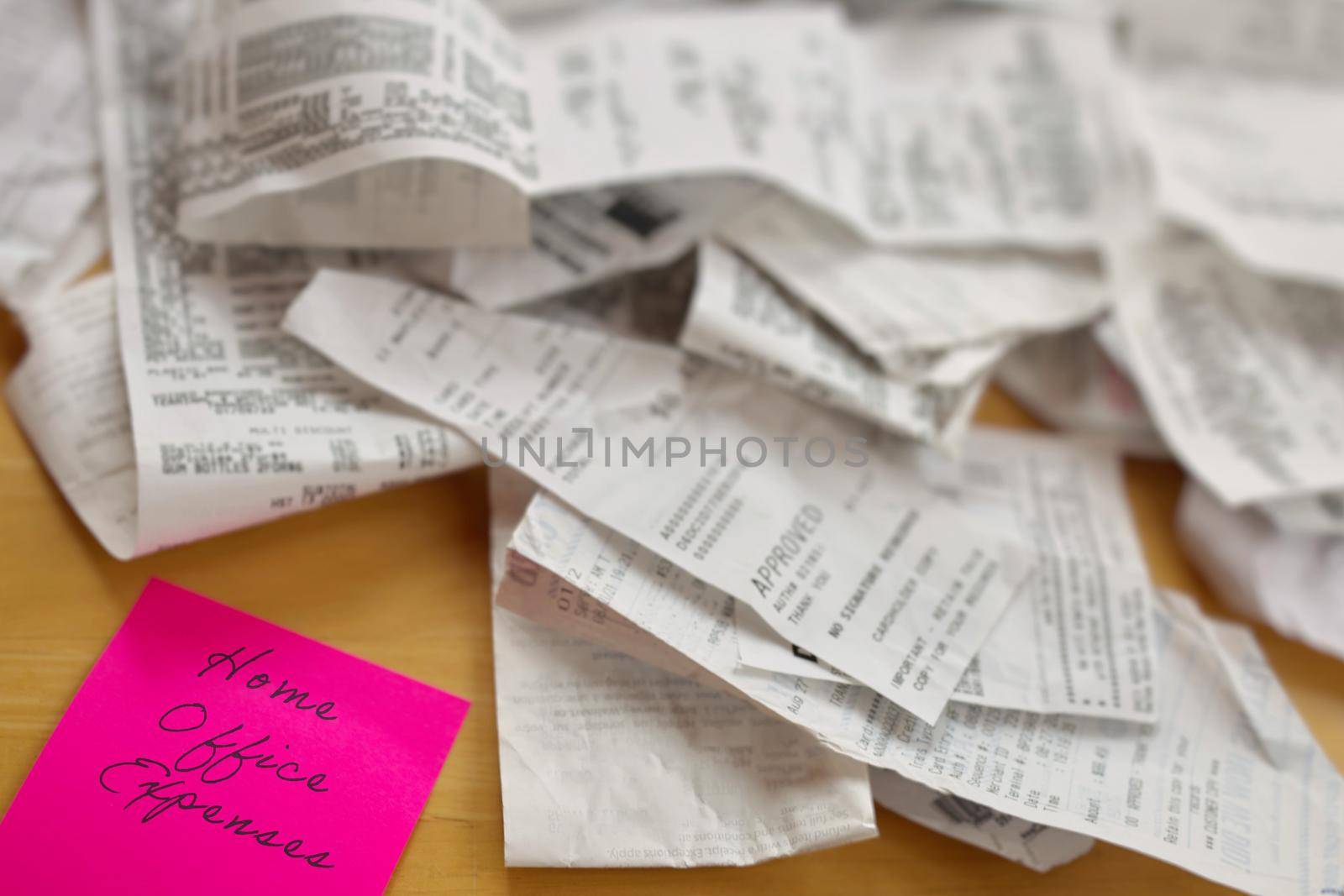 High Angle View of Pile of Receipts with Home Office Expenses Pink Sticky Note on Table by markvandam