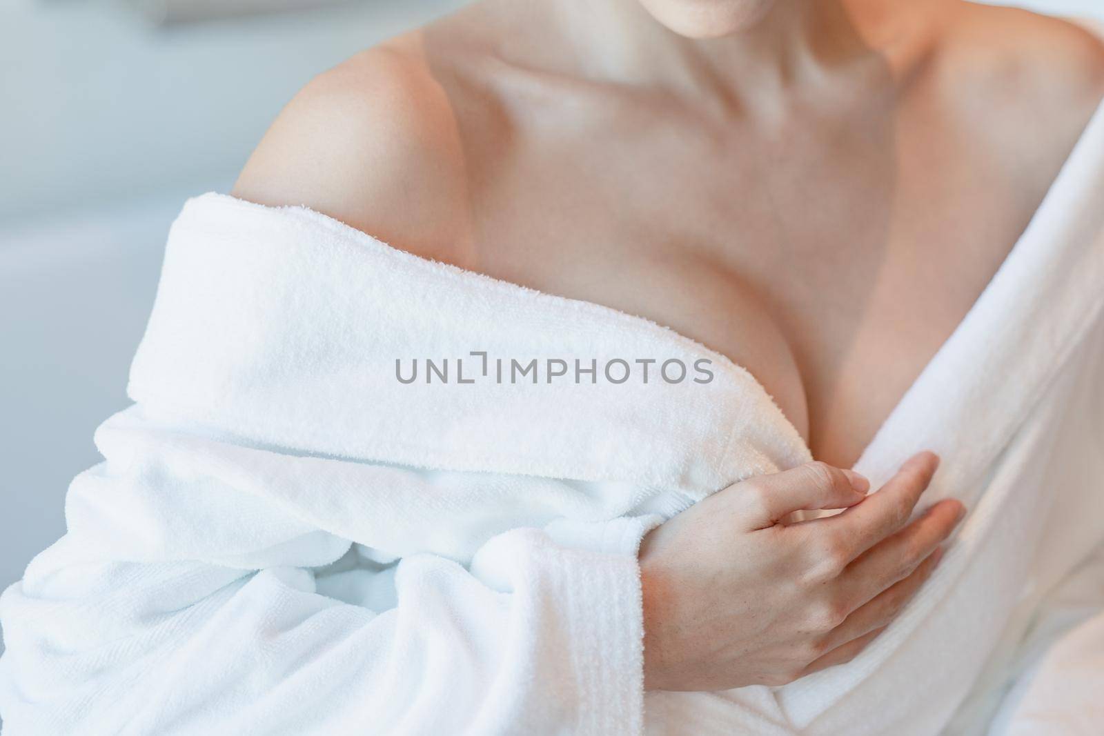 Woman in bathrobe, close up on chest. by sirawit99
