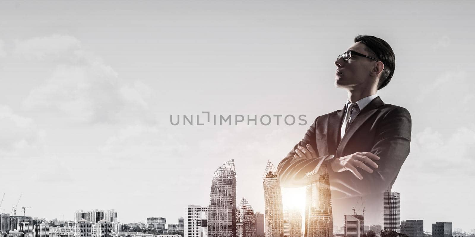 Double exposure of elegant businessman and modern busines city with towers and skyscrapers