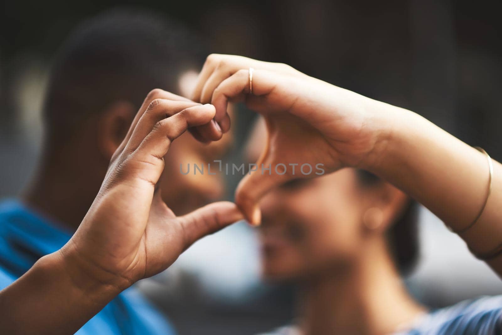 My heart will always be yours. Cropped shot of a young couple making a heart gesture with their hands outdoors. by YuriArcurs