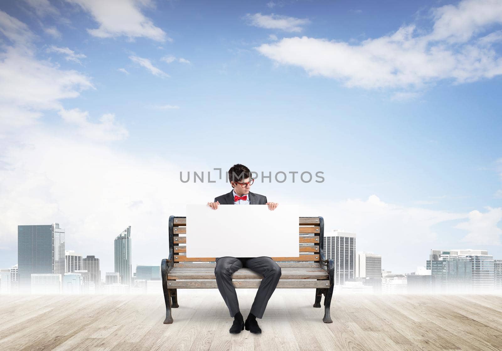 Young businessman holds a large white banner. sits on the bench