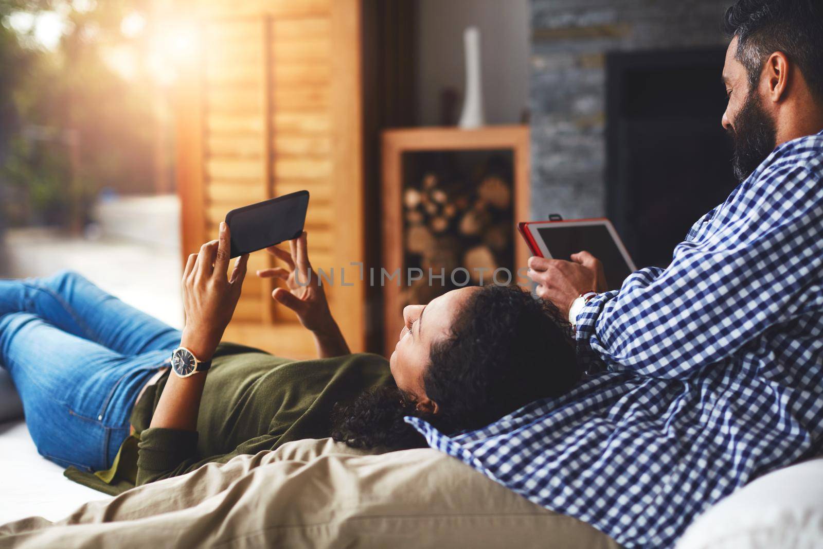 Shot of a laid-back couple relaxing with wireless technology at home.