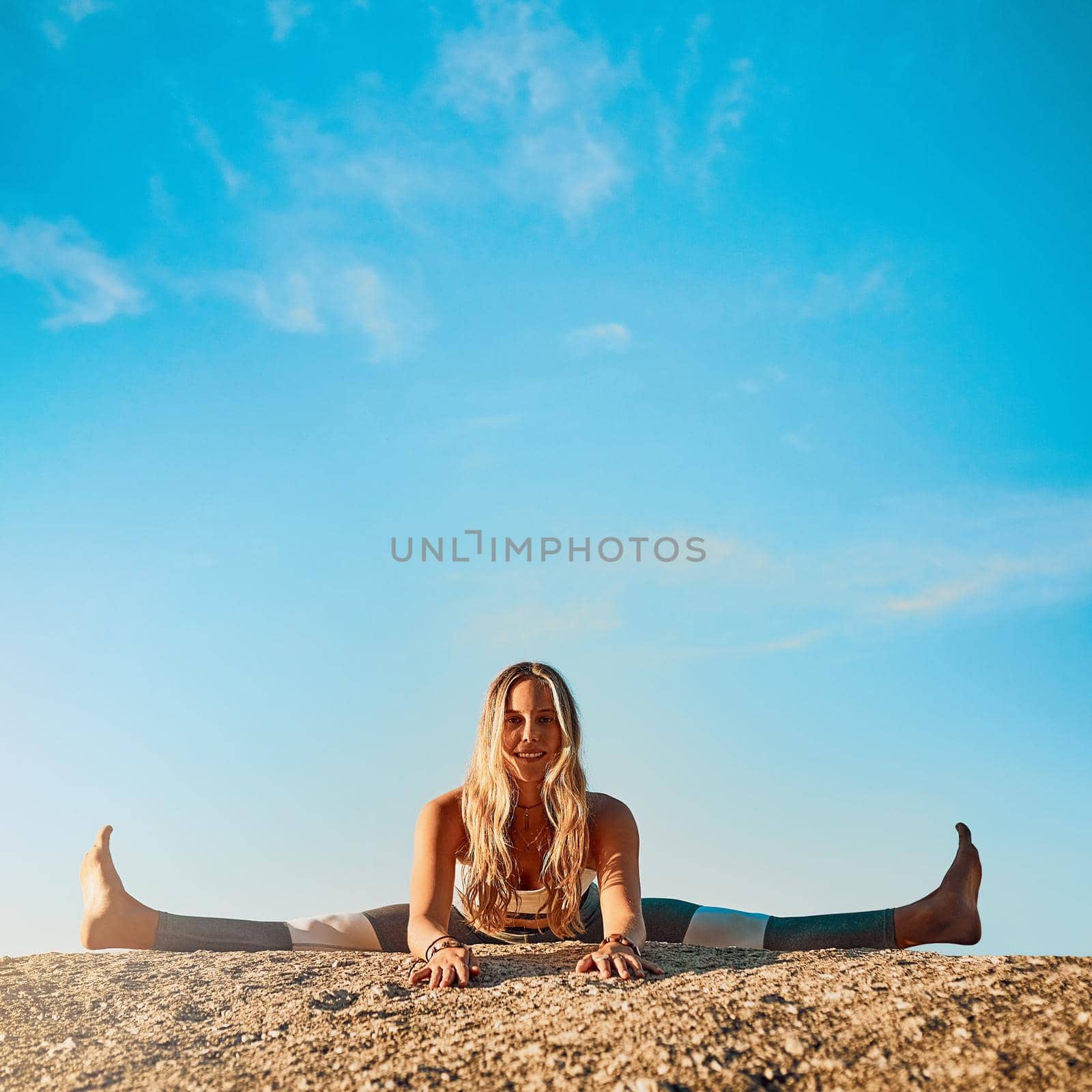 Yoga is more than just an exercise. Shot of an athletic young woman practicing yoga on the beach. by YuriArcurs