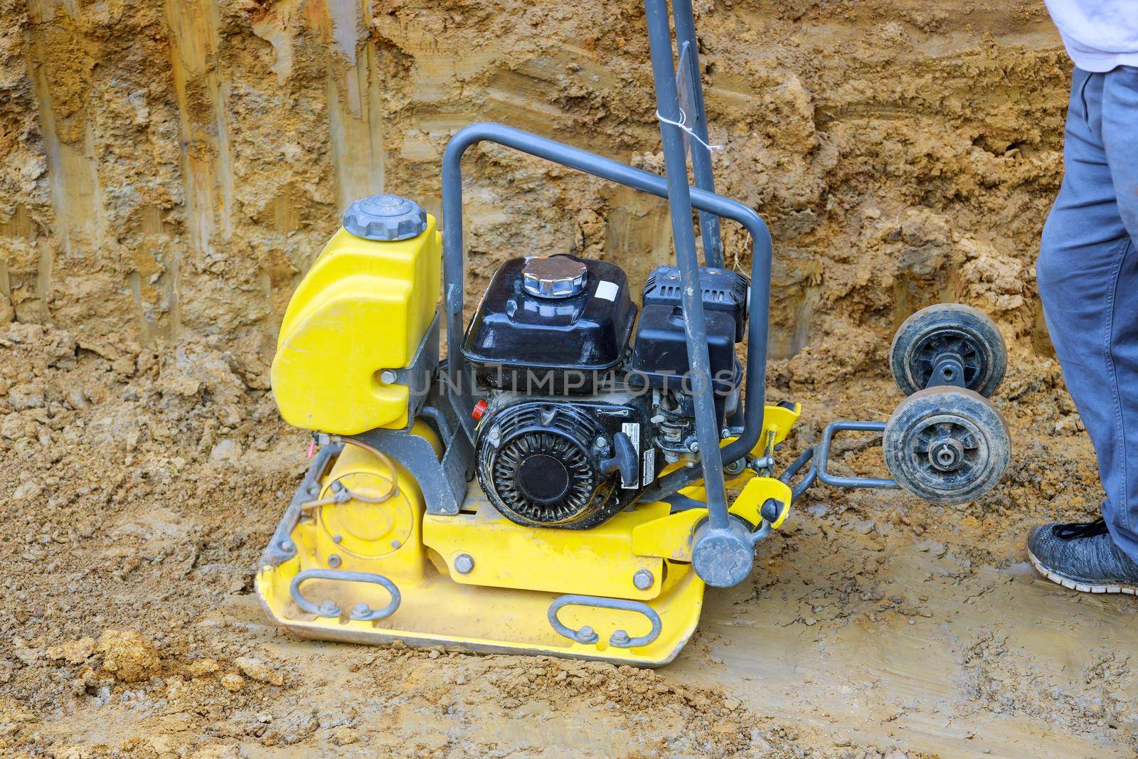 Vibrating compresses the soil of a surface during construction works in earthworks