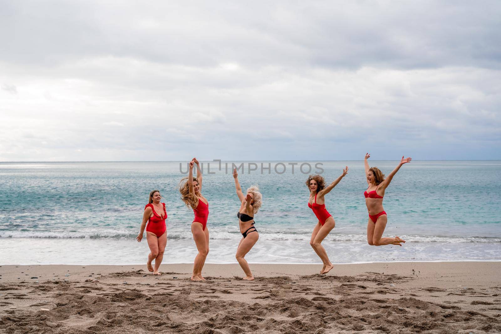 Big happy family or group of five friends is having fun against sunset beach. Beach holidays concept