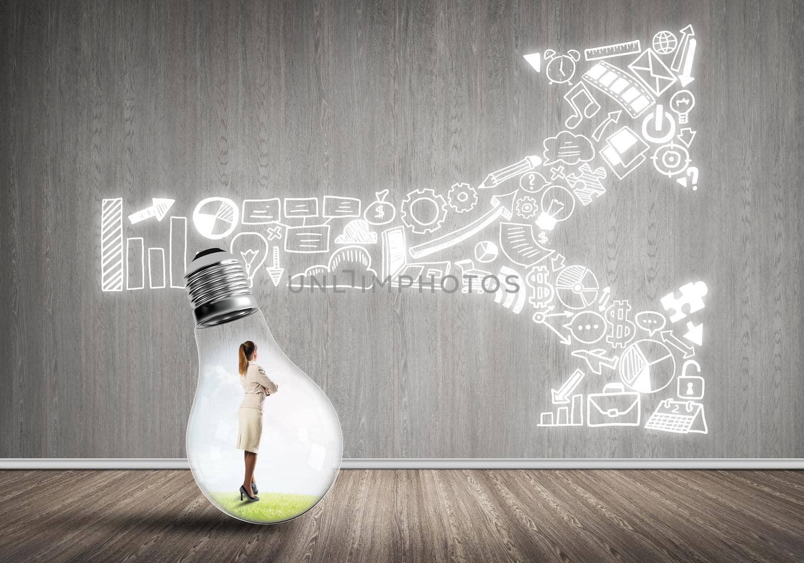 Businesswoman inside of light bulb in empty concrete room