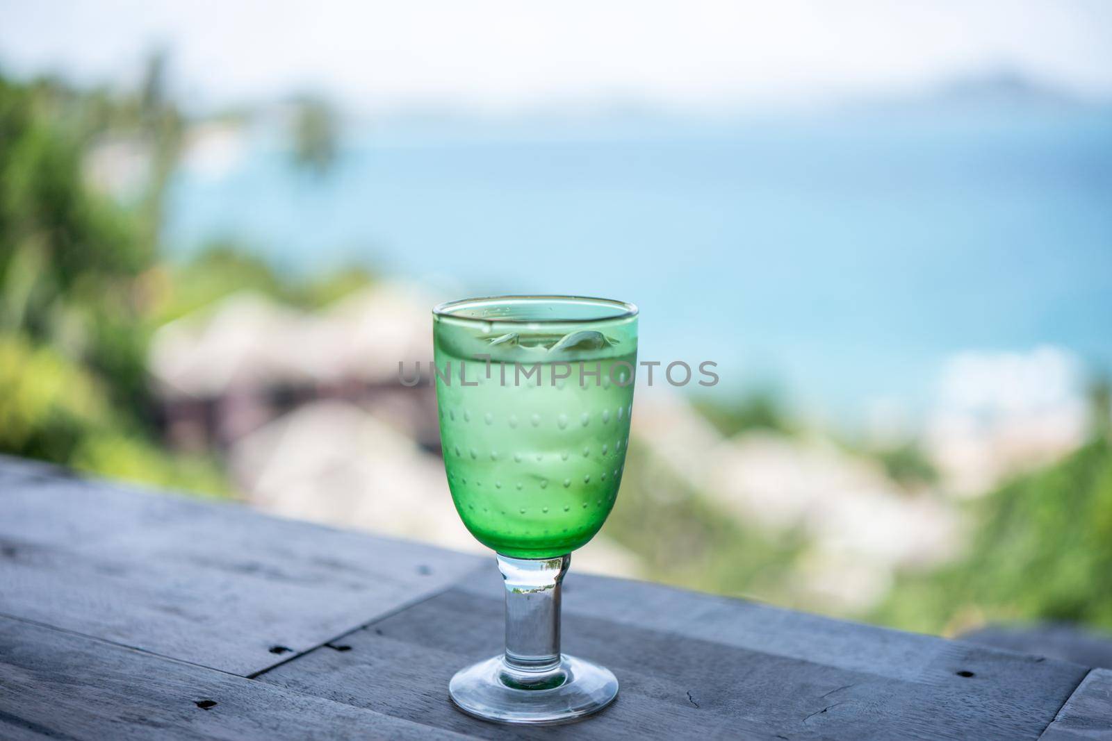 Glass of drinking water with ice over blur ocean background. by sirawit99