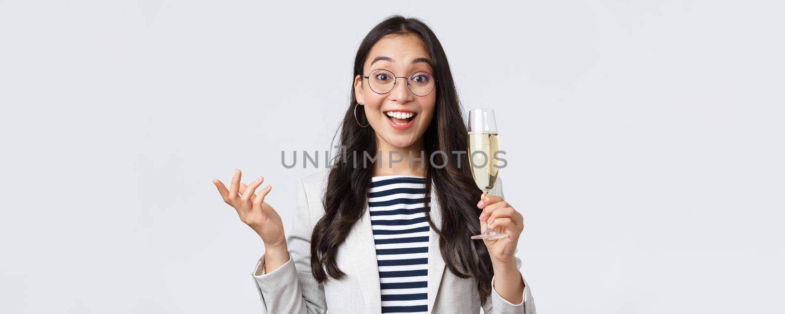 Business, finance and employment, female successful entrepreneurs concept. Enthusiastic happy businesswoman celebrating good deal, have office party with coworkers, make toast with glass champagne.