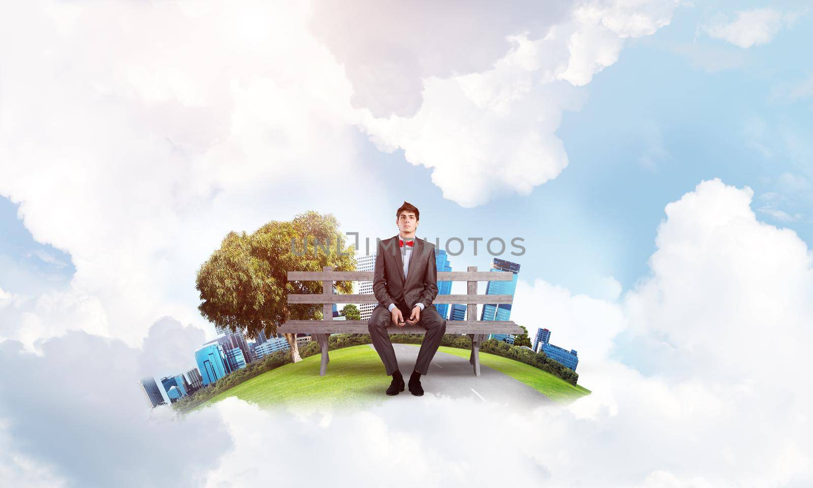 young student on the bench. holds glasses