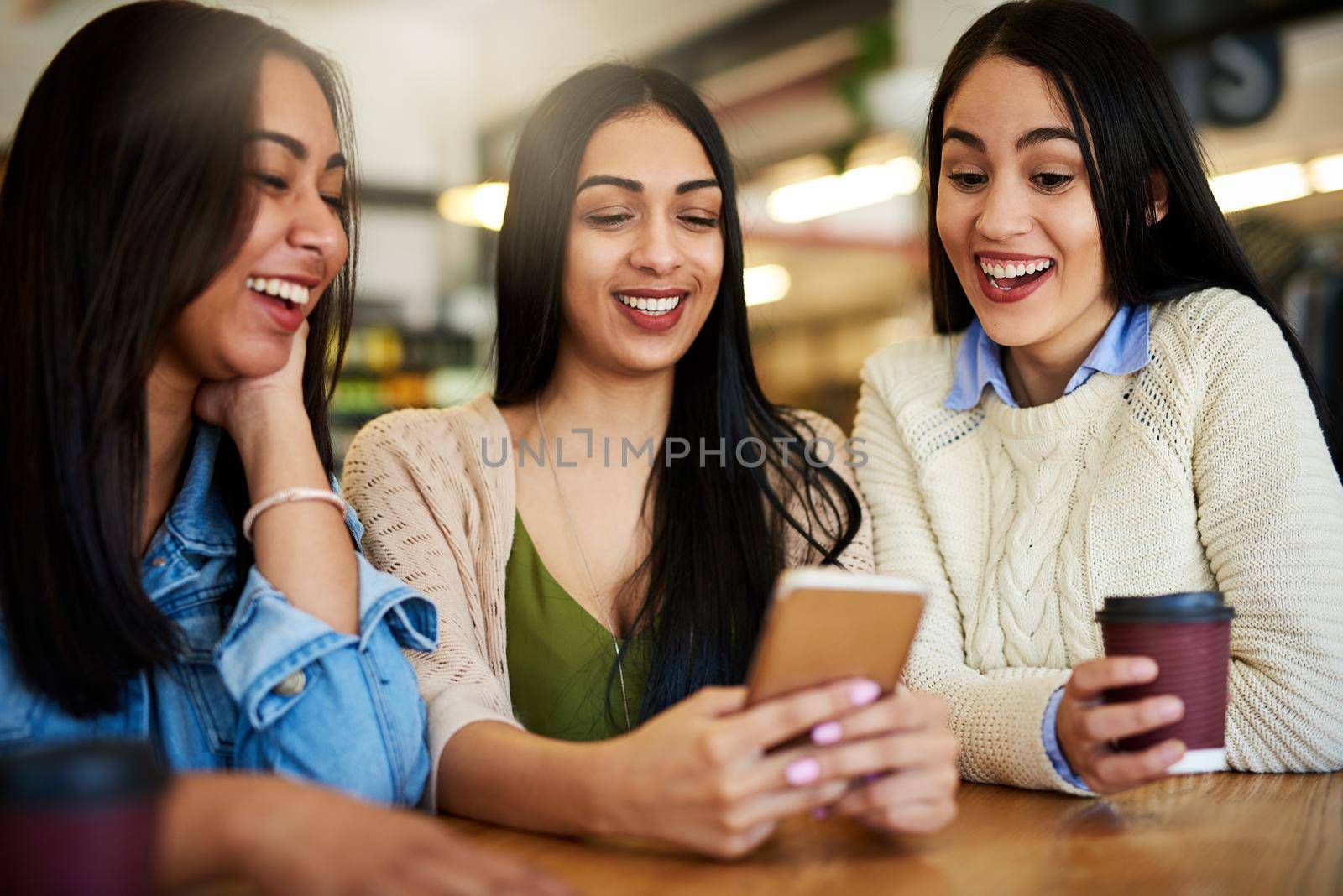 Cropped shot of a group of young friends hanging out in a cafe.