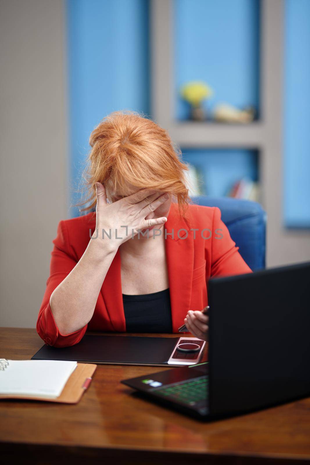 Overworked and stressed businesswoman working on laptop at the office