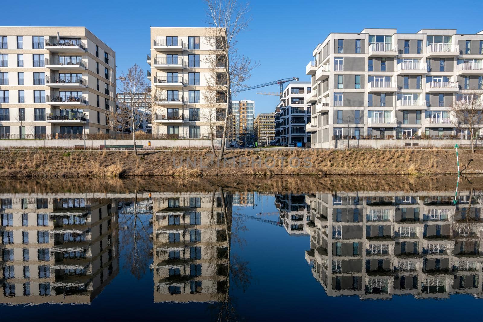 Modern apartment buildings in Berlin, Germany, reflecting in a small canal