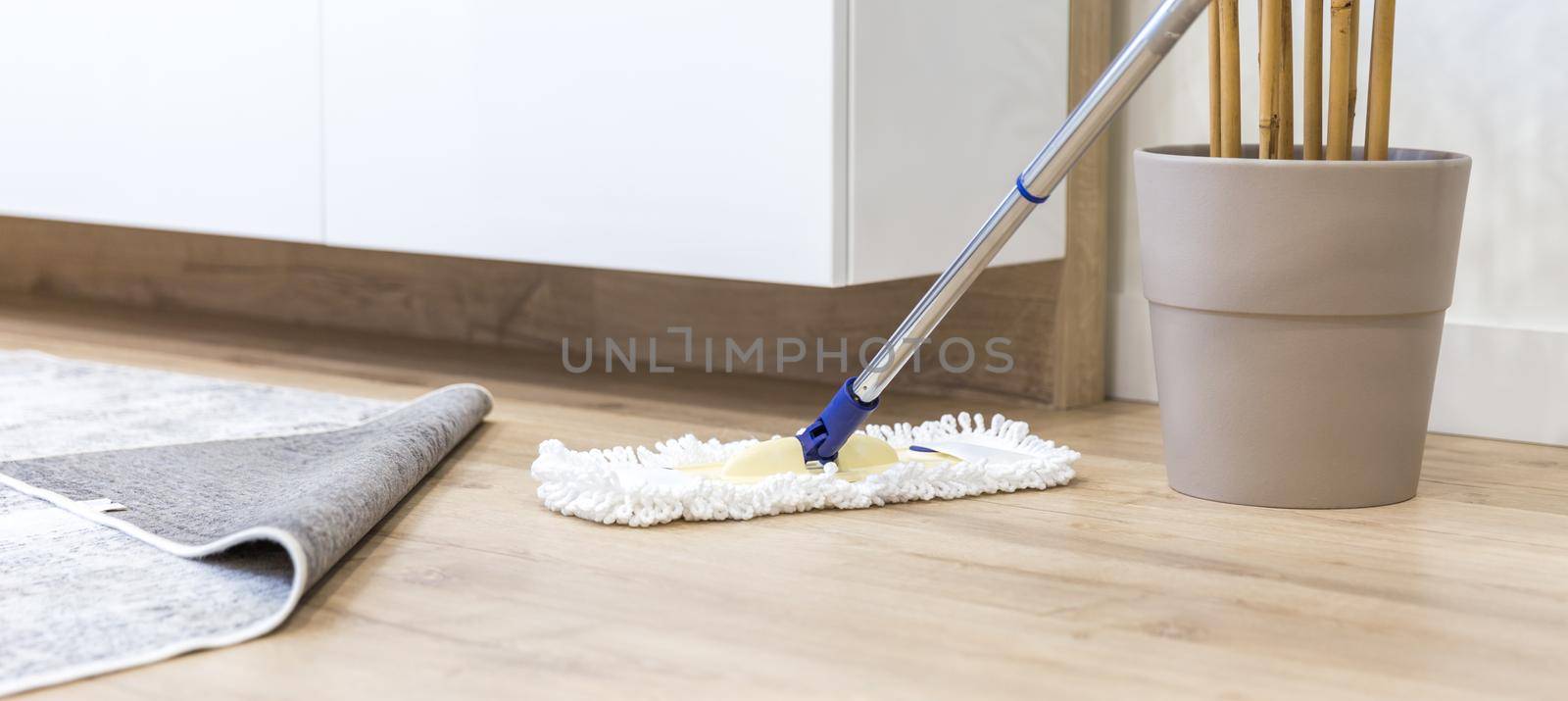 Wooden floor with white mop, cleaning service concept by Mariakray