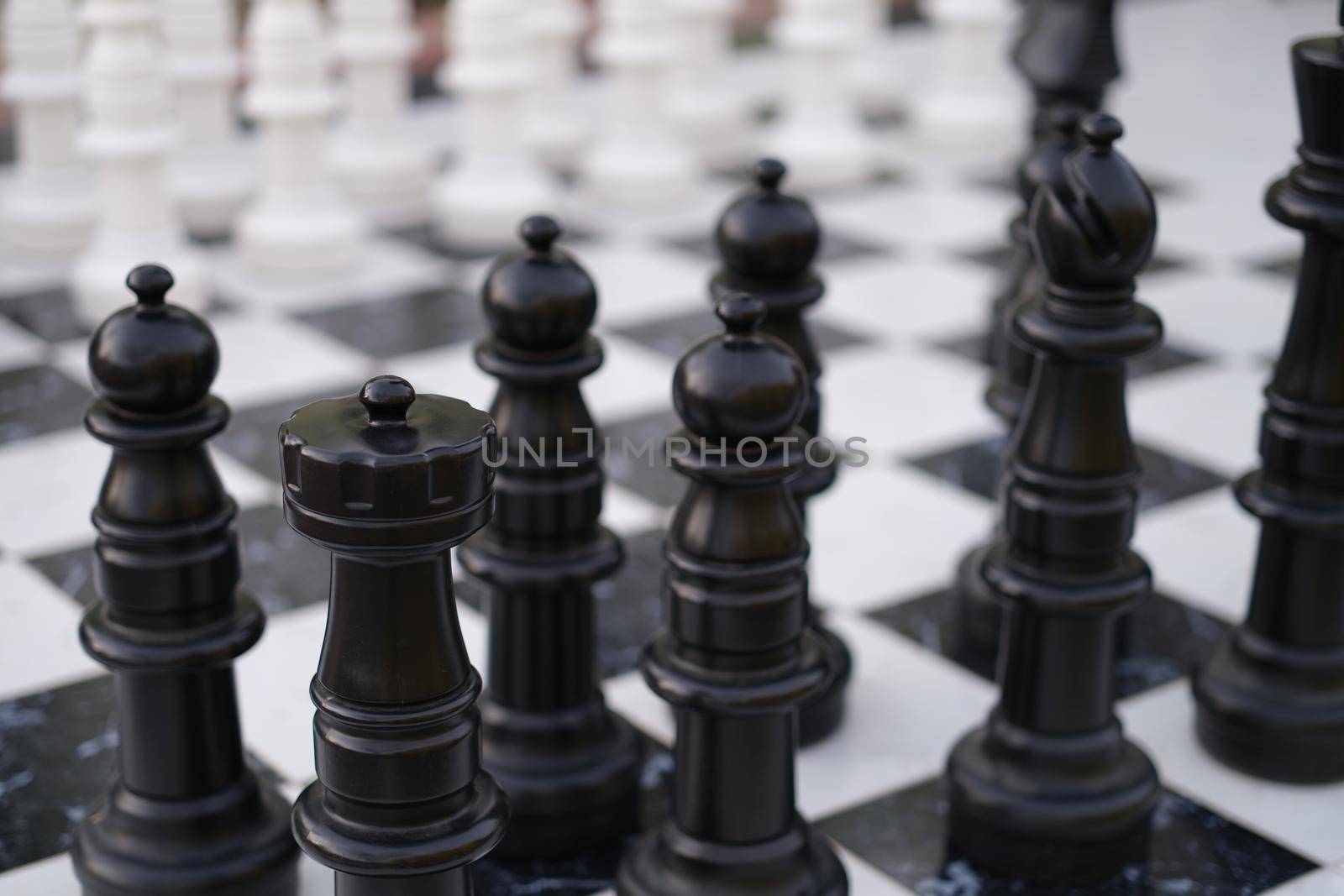 Black and white chess pieces standing on boards on street closeup. Holding chess tournaments concept