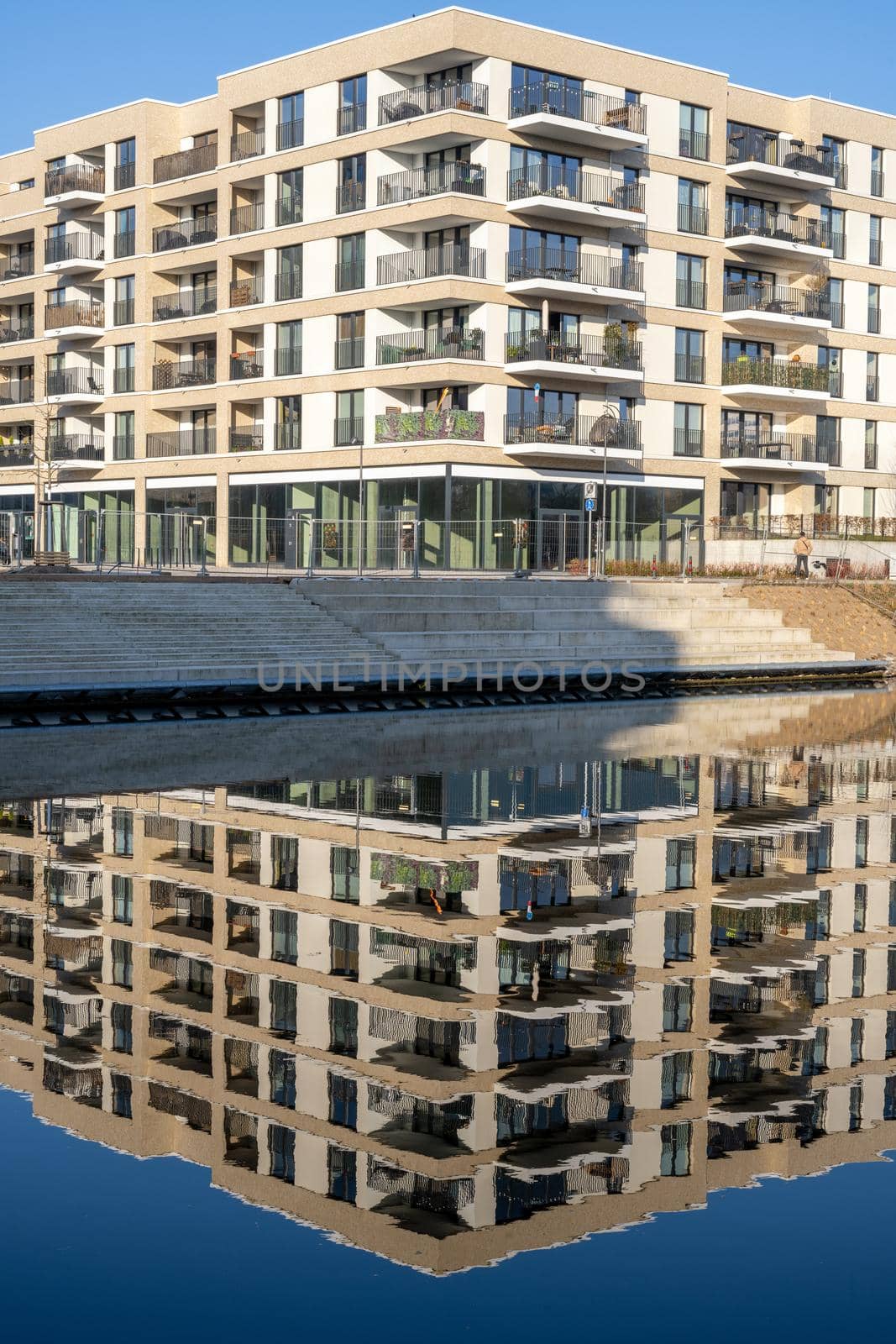 New apartment building in Berlin, Germany, reflecting in a small canal