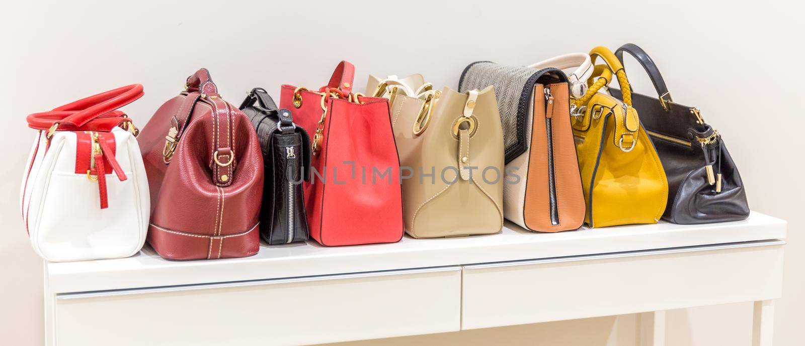 Collection of handbags standing in a row by Mariakray