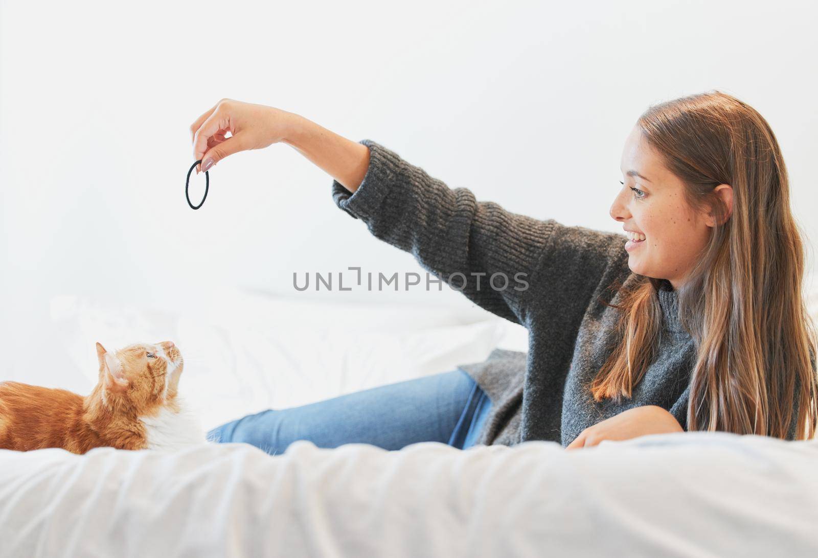 Shot of a young woman playing with her cat at home.