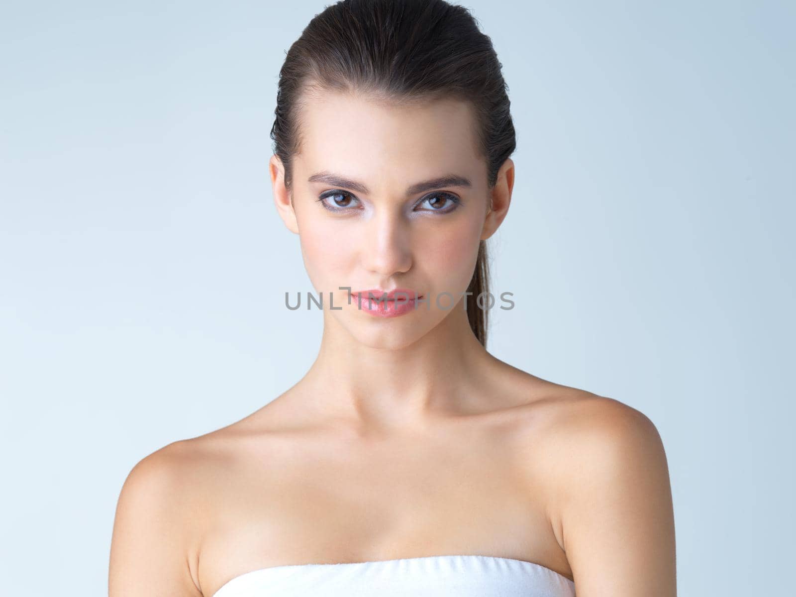 Studio portrait of a beautiful young woman posing against a blue background.