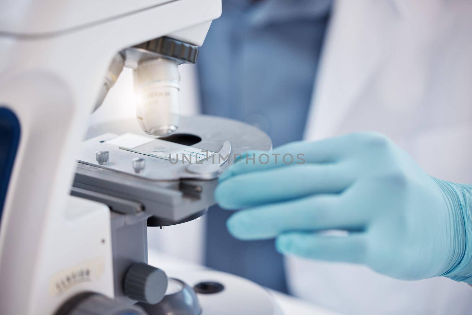 Shot of a unrecognizable scientist using a microscope in a laboratory.