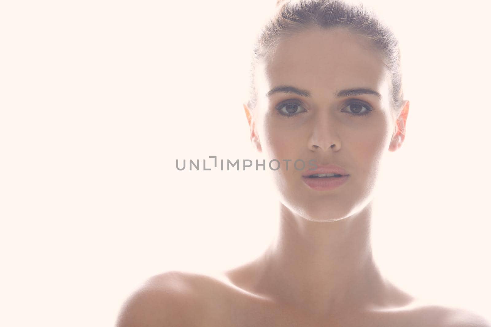 Perfect is the best way to describe her. Cropped shot of a beautiful young woman posing against a light background. by YuriArcurs