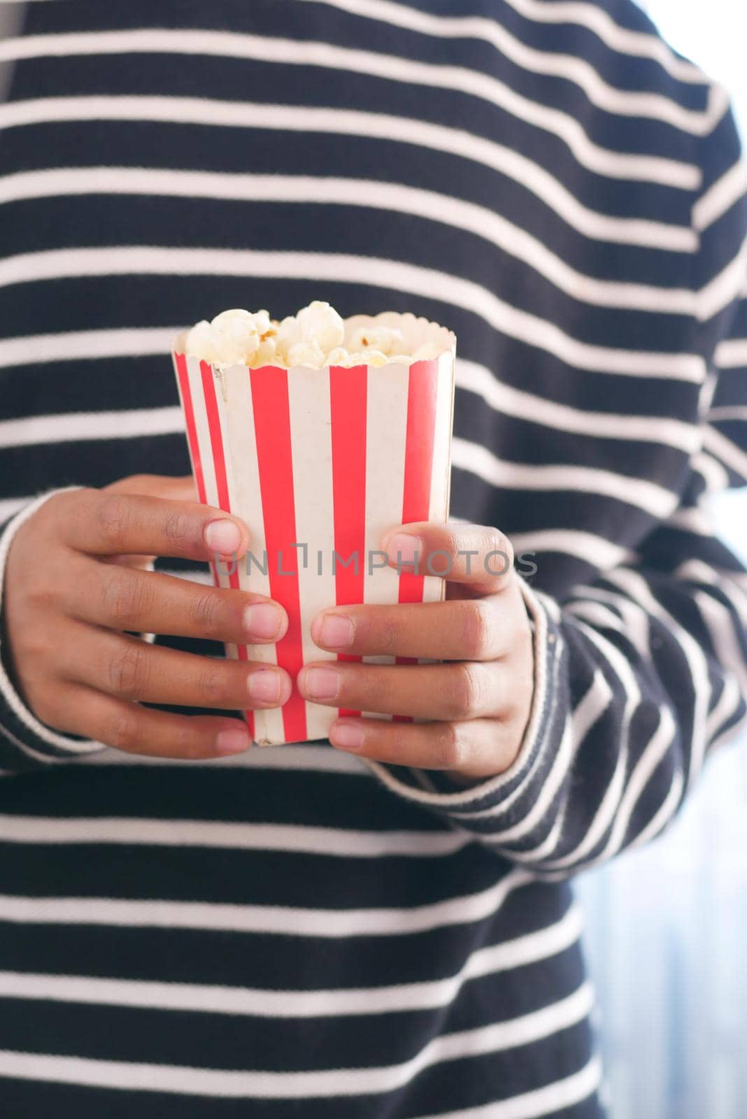 young man eating popcorn close up .