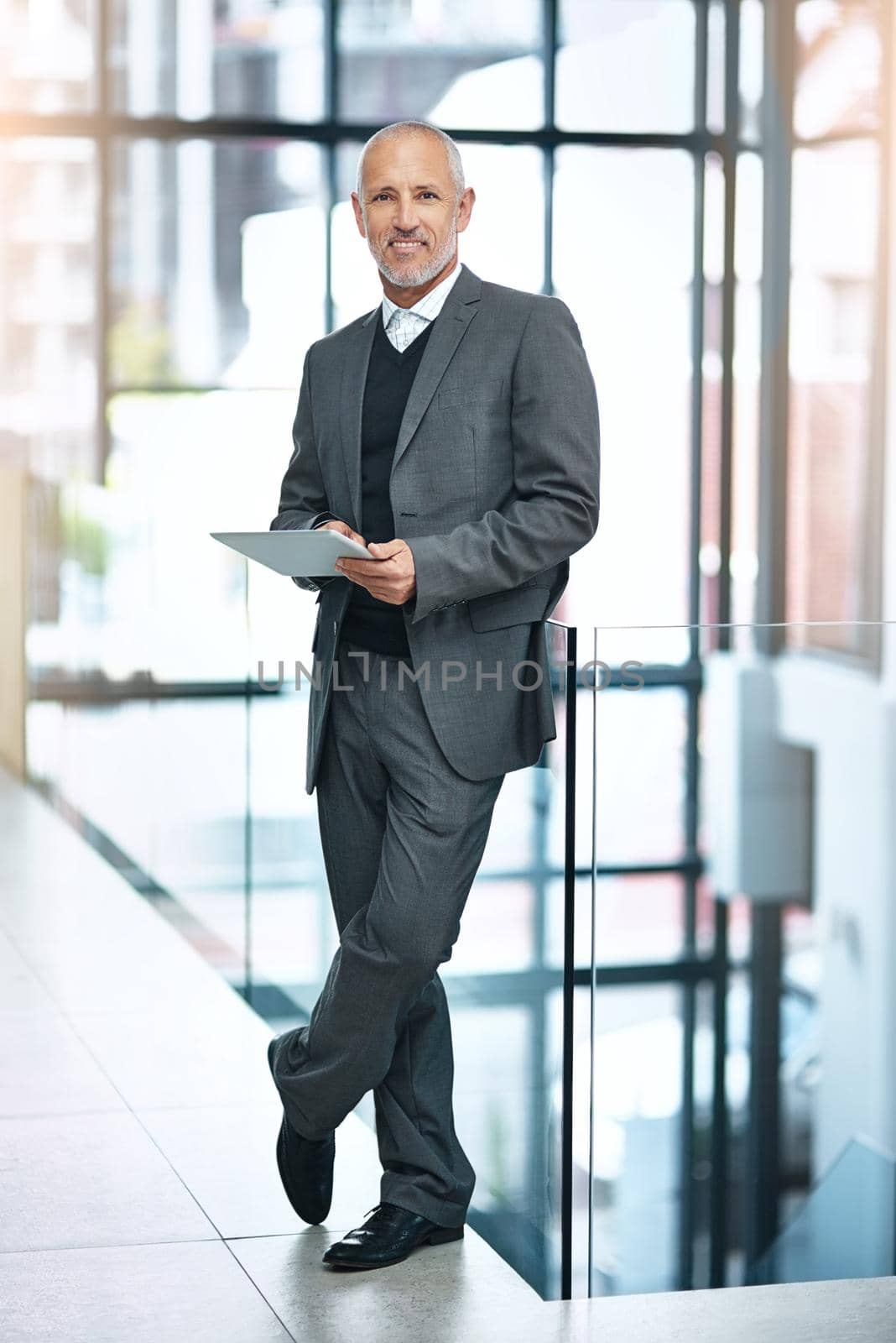 Shot of a mature businessman using his digital tablet at the office.