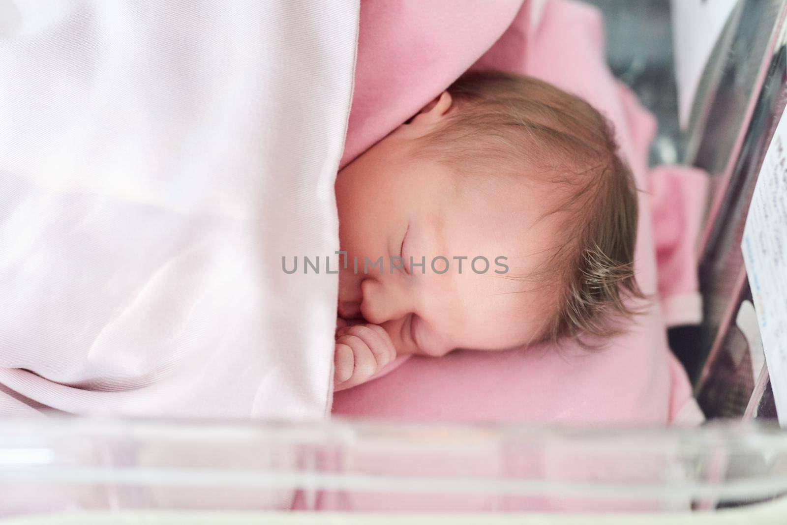 She needs all the sleep she can get. Shot of a newly born baby girl in the hospital. by YuriArcurs