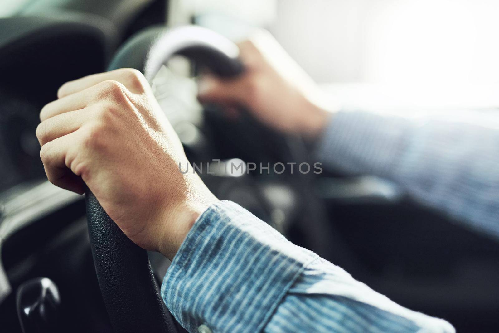 Hands at the ten and two oclock position. Closeup shot of a man driving a car. by YuriArcurs