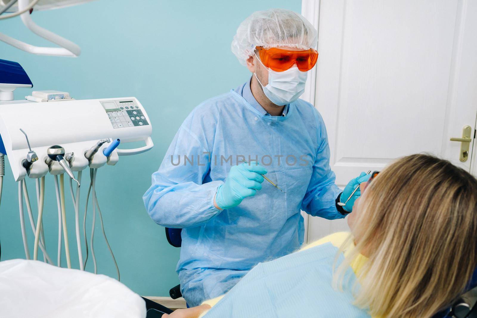 The patient treats her teeth at the dentist in the dental office . Dental fillings by Lobachad