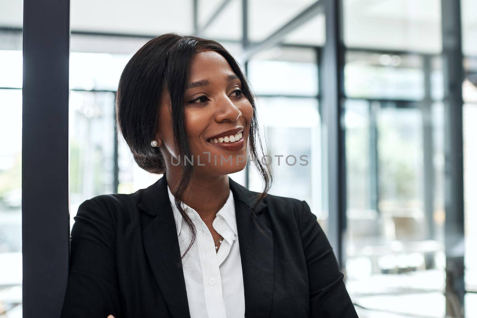 Shot of a confident young businesswoman looking away thoughtfully in a modern office.