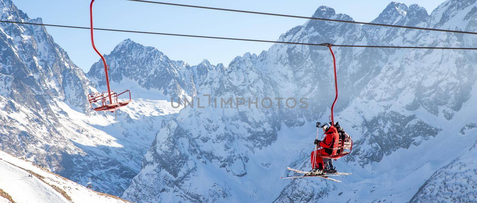 DOMBAI, RUSSIA - JANUARY 3, 2014: People are lifting on open lft high up in Caucasus mountains by Mariakray
