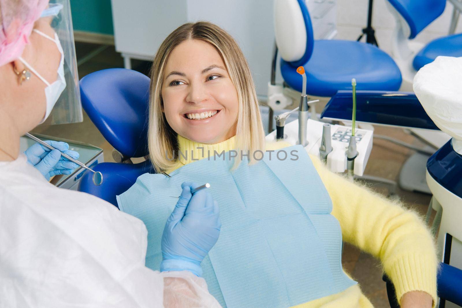 The girl smiles at the dentist and looks at her.