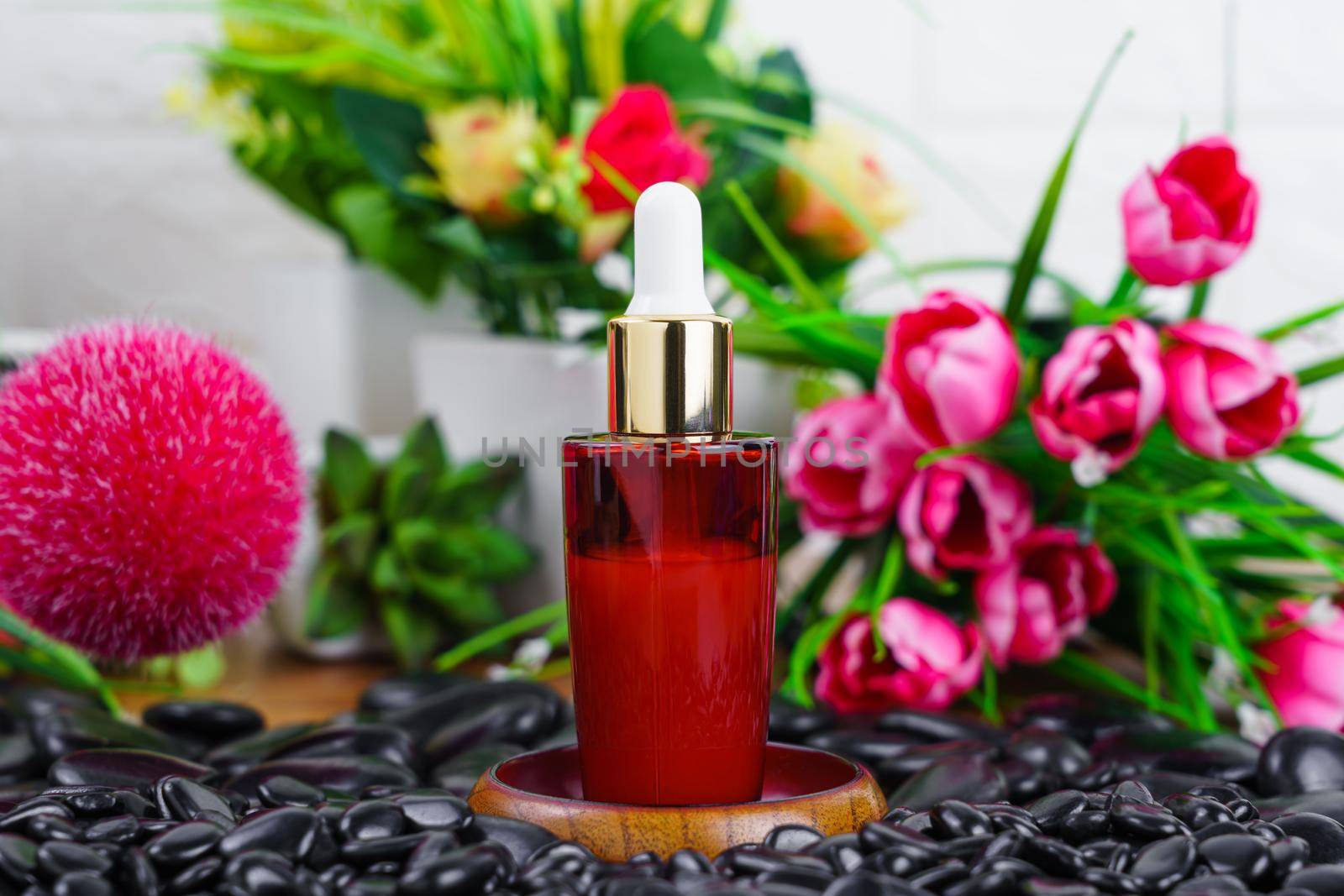 Thai Spa massage setting with red serum oil bottle dropper mock up  on black stone