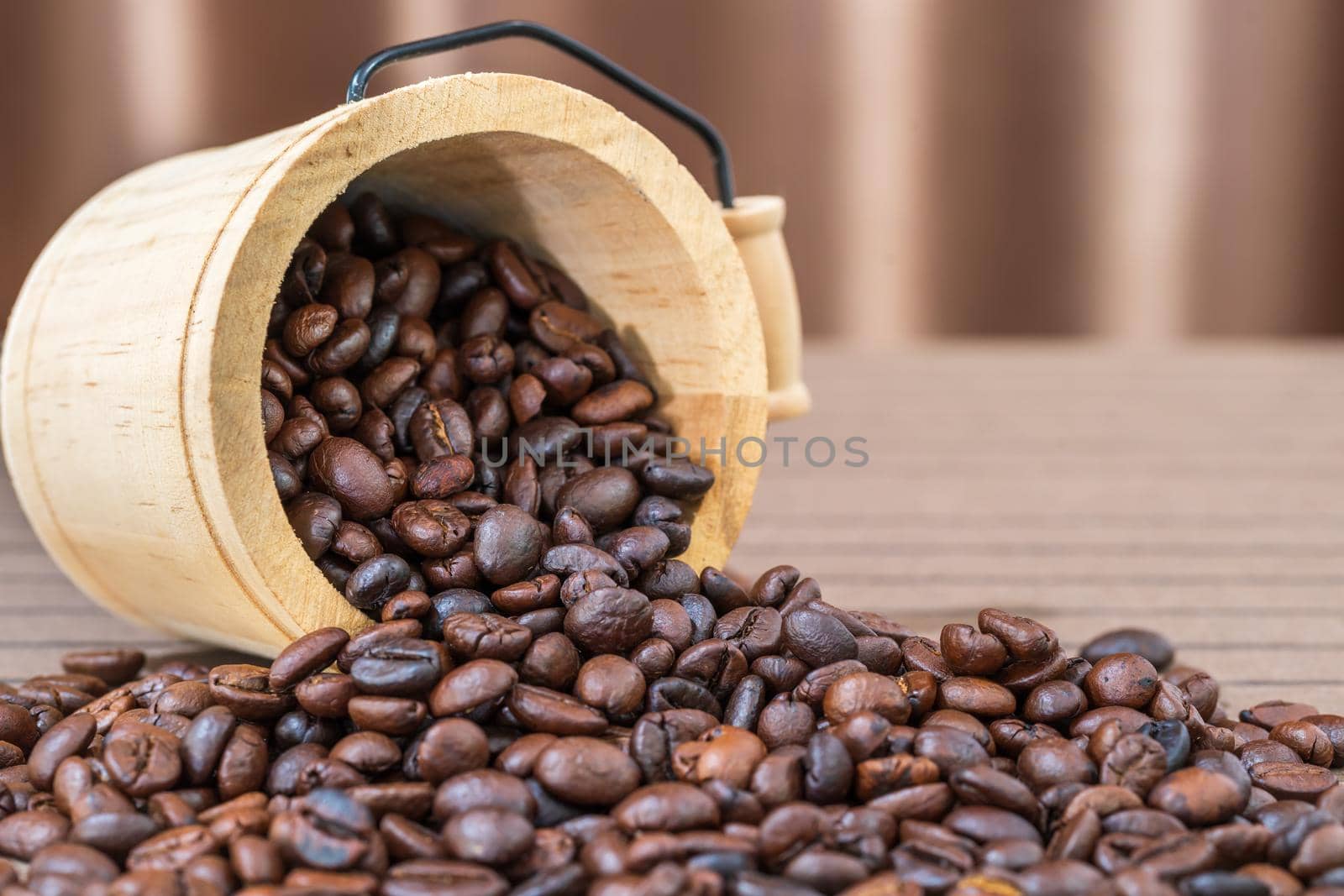 Close up wood cask with roasted coffee beans heap