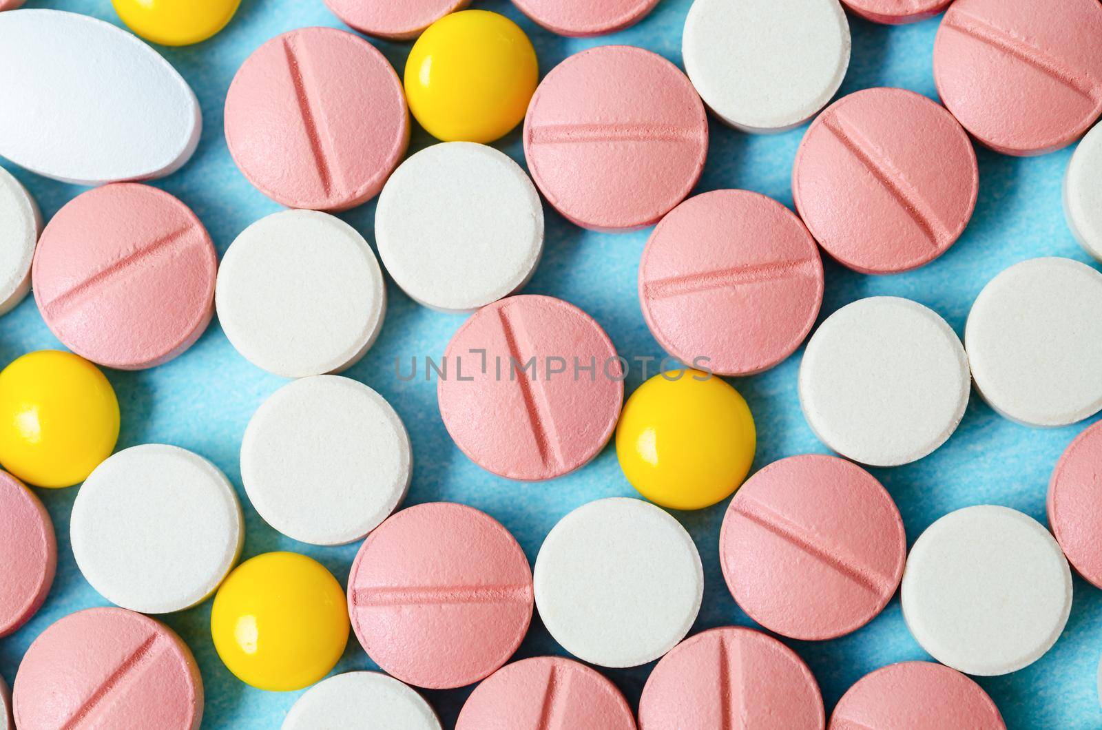 The Many colorful pills macro on blue background.