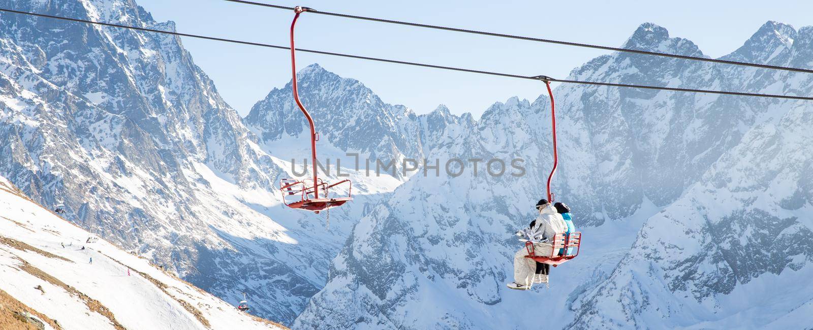 DOMBAI, RUSSIA - JANUARY 3, 2014: Touristsmoving up by ski lift in Dombai Caucasus mountains in Russia