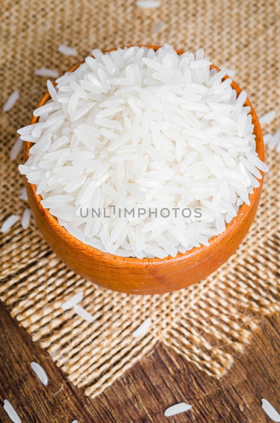 Rice in a bowl on wooden table by Gamjai