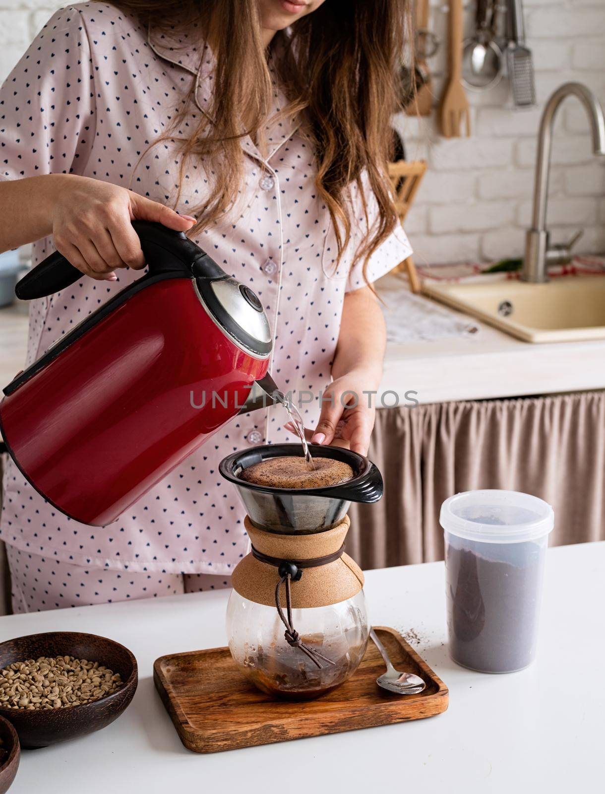 Alternative coffee brewing. young woman in lovely pajamas making coffee at home kitchen