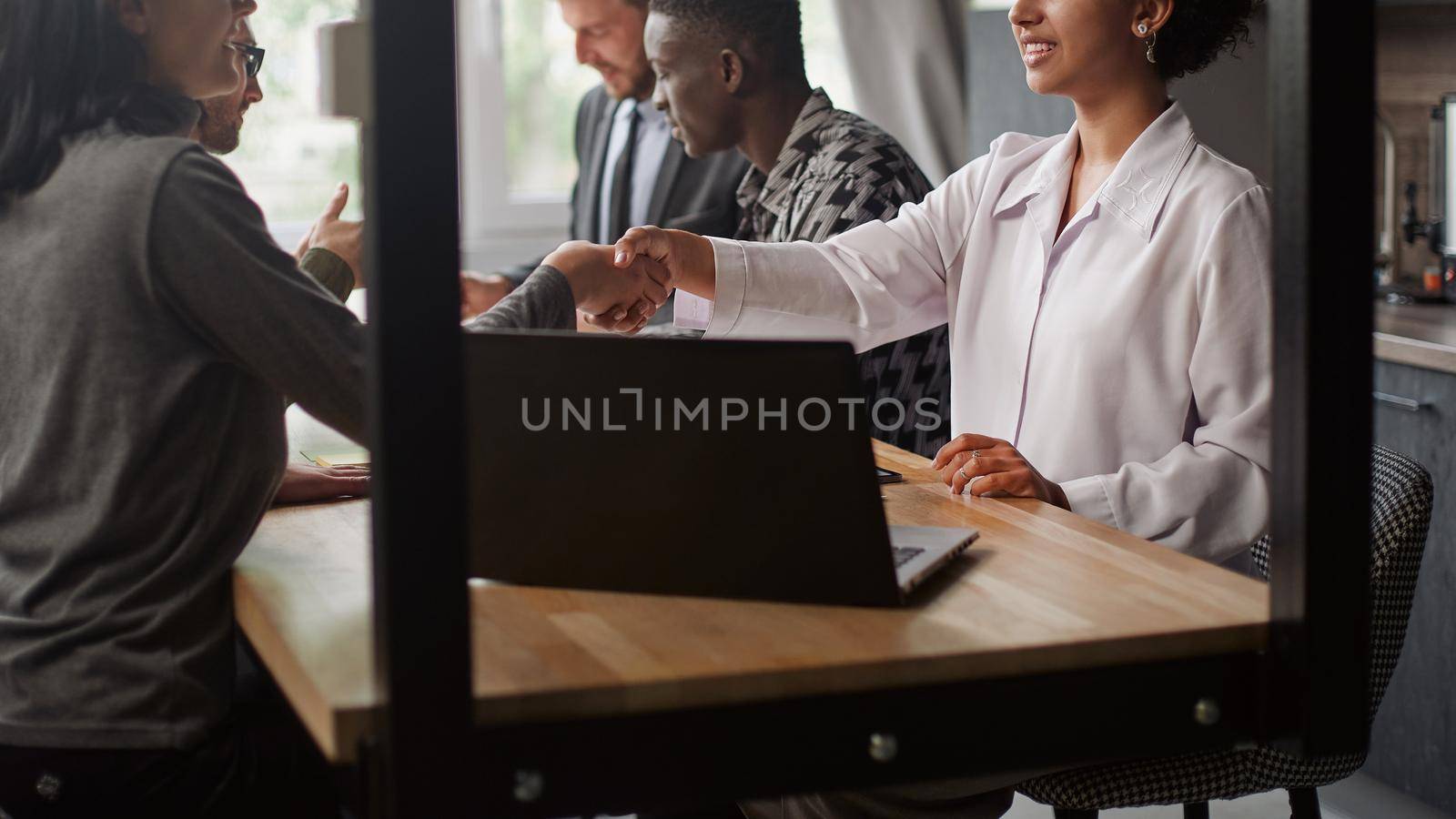 business woman greeting a client with a handshake. by SmartPhotoLab