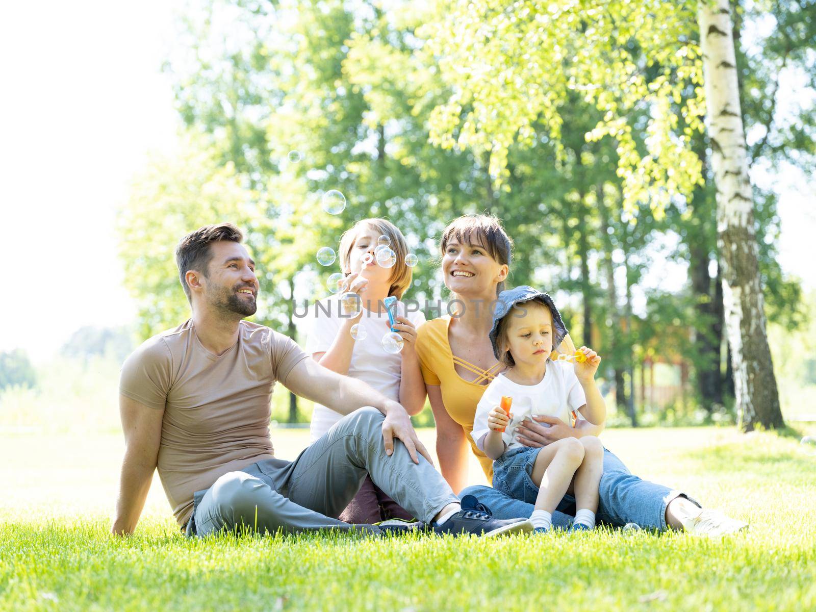 Happy family playing with soap bubbles by ALotOfPeople