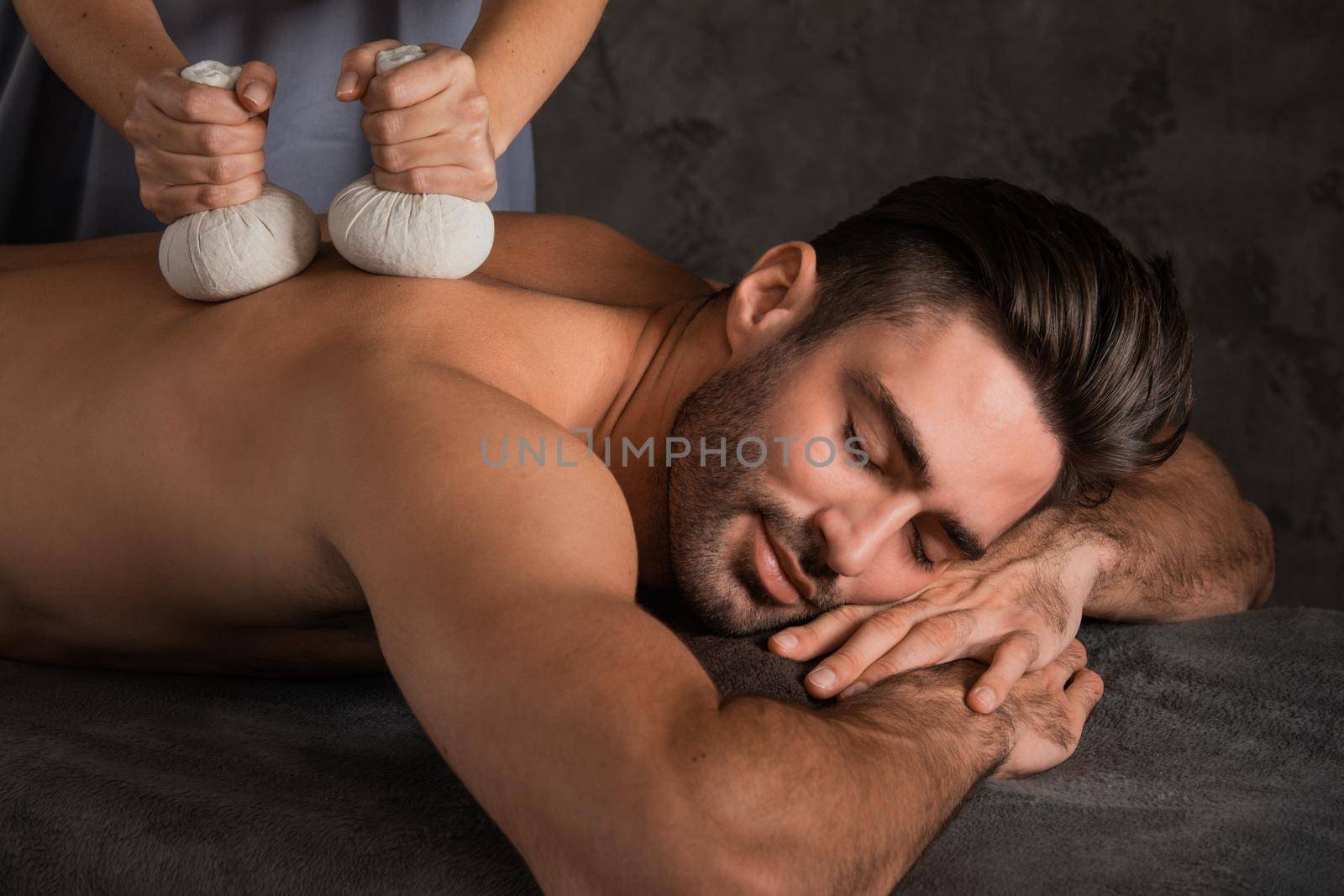 Man having back massage with pouche by ALotOfPeople