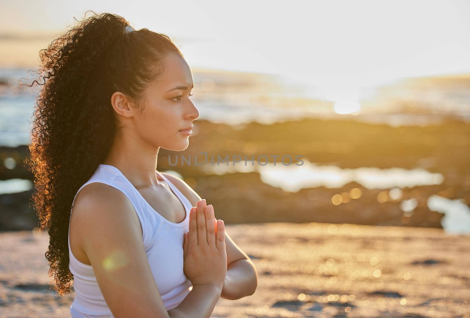 Cropped shot of an attractive young woman meditating on the beach.