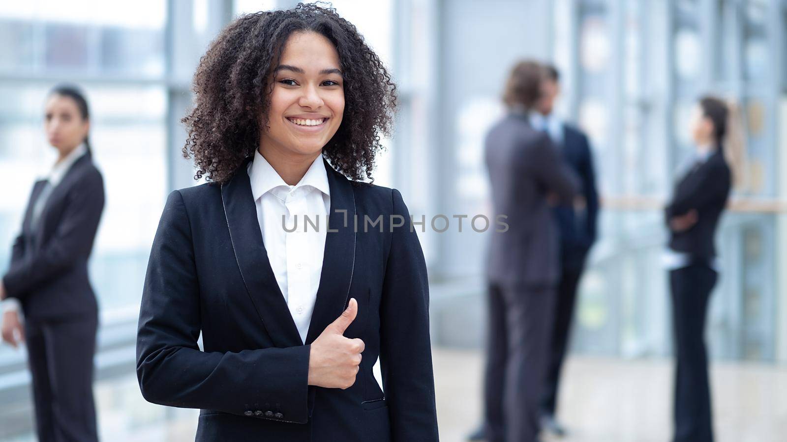 Mixed race ethnicity female employee worker looking at camera showing thumb up gesture recommending work study in her company